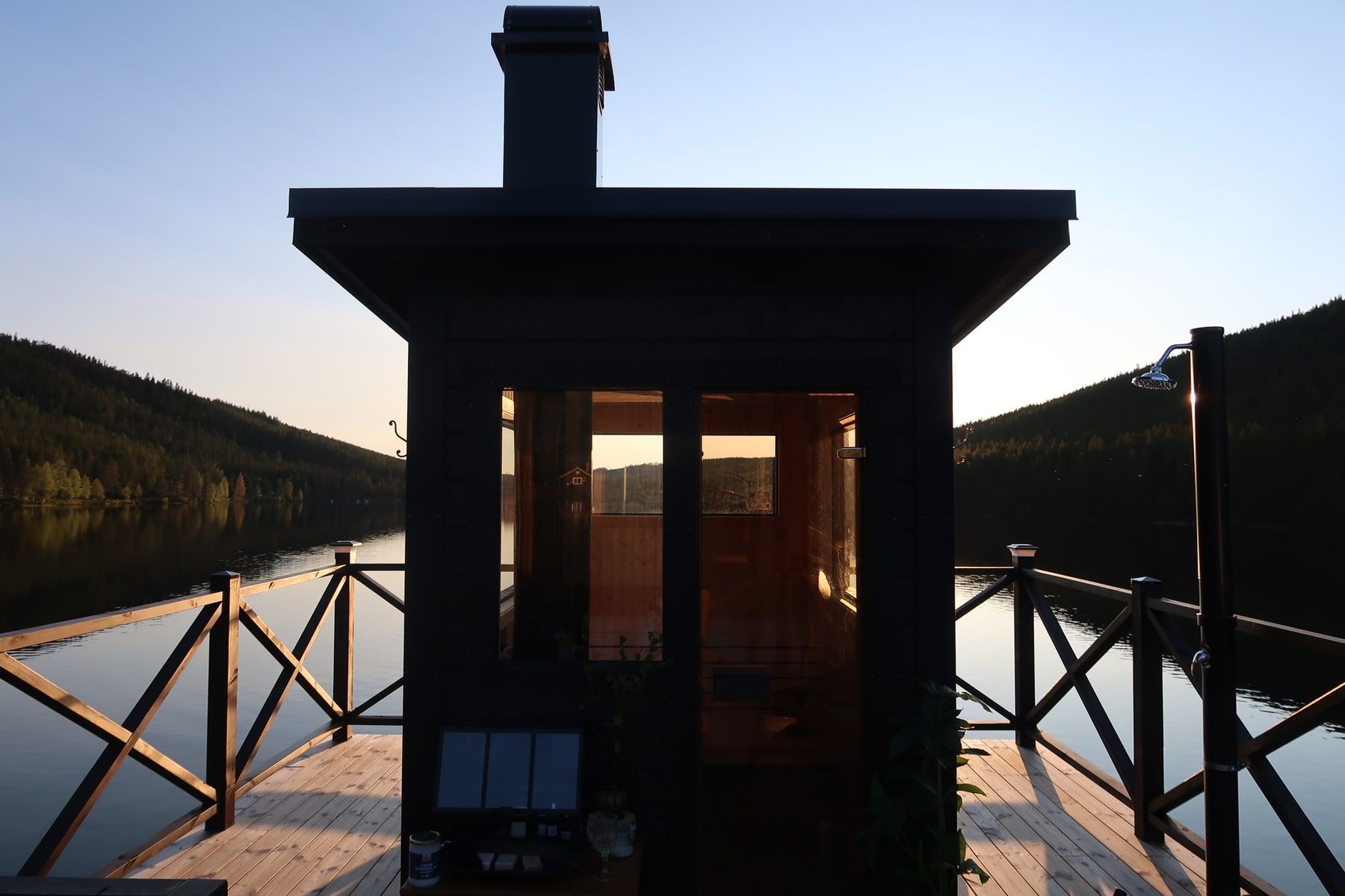 Raven’s rooftop sauna and outdoor shower on a wooden deck overlooking the lake.